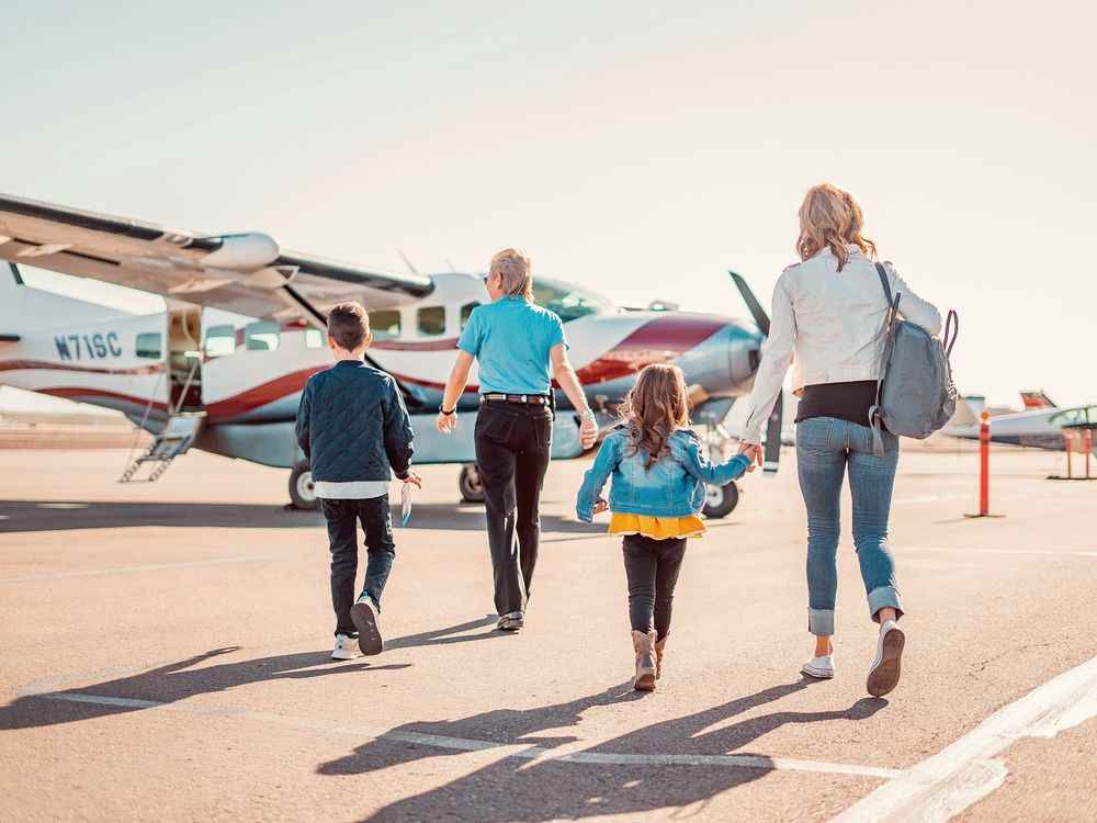 Família caminhando pela pista depois de descer de um avião particular
