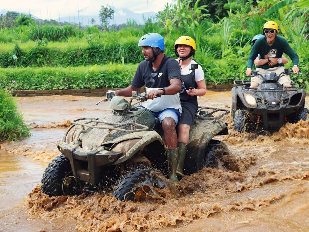 Amigos pilotando quadriciclos em uma trilha de lama