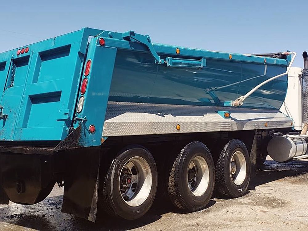 Caminhão basculante Kenworth do Grupo Ruli de perfil